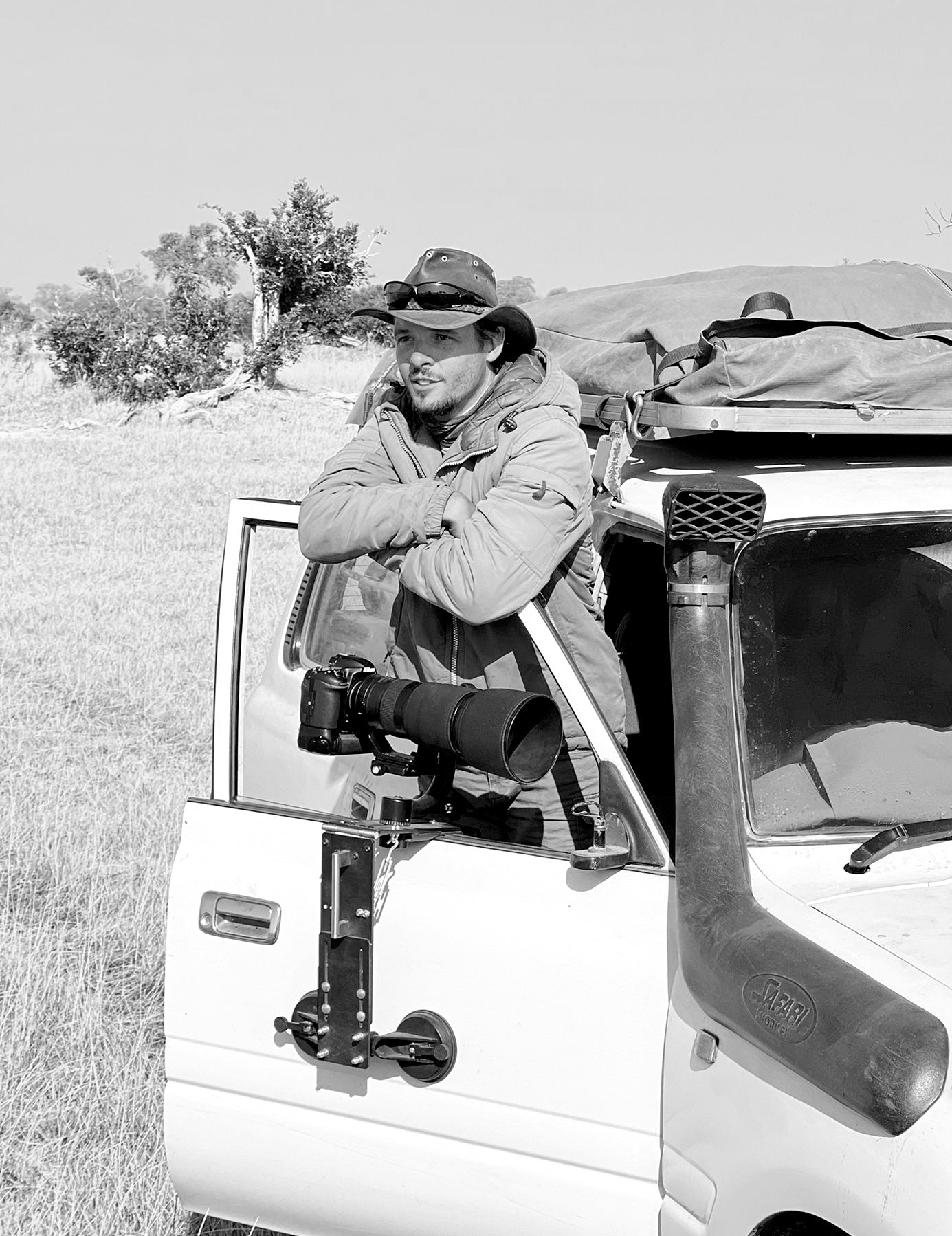 Photographer Devon Jenkin standing out from his vehicle on safari